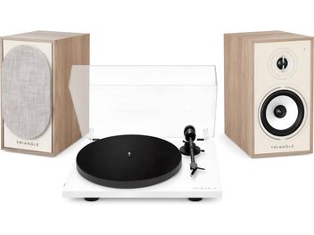 Hvit Triangle-vinylspiller med gjennomsiktig lokk og et par matchende høyttalere i lys trefinish, sett forfra