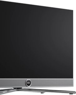 Musta Loewe Vega 32 -taulutelevisio, ohut kehys ja hopeinen kaiutinpalkki etupuolella