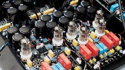 Vnitřní obvod hi‑fi lampového audio zesilovače, černé kondenzátory a červená relé na elektronické desce