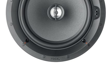 Altoparlante circolare incassato, telaio in plastica nera opaca, membrana grigio antracite con texture e tweeter centrale argentato protetto da una barra metallica, viti e indicatori arancioni visibili sul perimetro, vista frontale