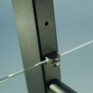 Nærbillede fra siden af et møbel til audio/video i mat sort metal med en metalstang, der går gennem et rundt hul