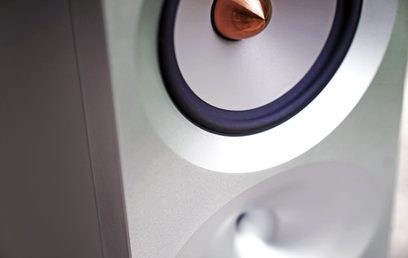 Thrax Audio Lyra baltų knygų lentynų garsiakalbis, iš arčiau matomas apvalus juodas garsiakalbis baltame korpuse