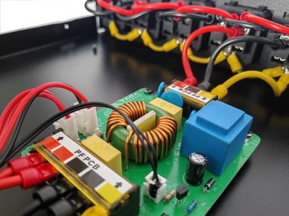 Innside av nettstrømskondisjoner Taga Harmony PF-2000 (2025) nærbilde grønt PCB metall/plast kobberspole og blå blokk