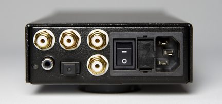 Svart lydkabinett, bakside med fire forgylte RCA-kontakter, jackkontakt, bryter og strømtilkobling