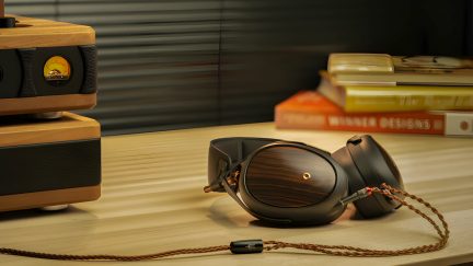 Occhiali da sole pieghevoli, libri impilati, cavo intrecciato su superficie in legno chiaro, vista ravvicinata frontale
