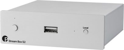Netzwerk-Audioplayer Stream Box S2 in hellem Metall, Frontansicht aus einem Winkel, runder Knopf links, zentraler USB-Anschluss, "Local"-Taste rechts