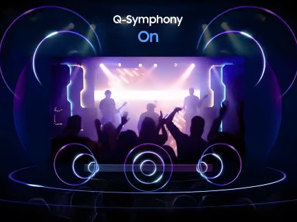 Silhuetter af personer på en oplyst scene foran en skærm, der viser "Q-Symphony On", omgivet af blå og lilla cirkulære neonlys