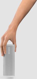 Female hand holding a cylindrical white Sonos Roam Lunar White Bluetooth speaker with a perforated pattern