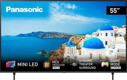 Panasonic TX-55MX950E 55 tommer fladskærms-TV, frontvisning, der viser et kystlandskab med blå og hvide bygninger