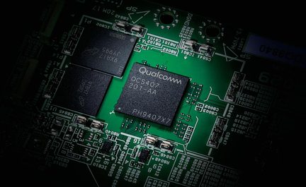Carte électronique verte avec puce Qualcomm QCS407 201-AA centrale et composants noirs montés en surface