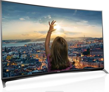 Televisore Panasonic TX-55CR850 che mostra una città al tramonto, una donna di spalle con il braccio alzato verso il cielo