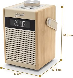 Rádio Roberts Rambler Midi v krémové barvě z krémového plastu s bočními panely ze světlého dřeva, perforovaným kovovým gril pod černým digitálním displejem s bílými číslicemi a stříbrným logem, velký kruhový hliníkový knoflík s kartáčovaným povrchem na horní straně a přizpůsobená boční rukojeť, pohled z pravého předního tříčtvrtečního úhlu
