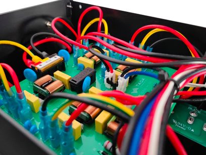 Interno del condizionatore di rete Taga Harmony PC-5000, chassis in metallo nero, PCB verde con bobine e cavi colorati