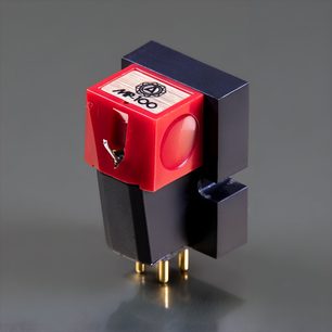 Nagaoka MP-100 hi-fi cartridge, black and red plastic, three-quarter view, square red cover with logo on top and circular side window, black body with four gold-plated connection pins at the base