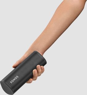 Bærbar Sonos Roam Bluetooth-højttaler i Shadow Black, holdt i en hånd, set fra siden, med mat sort tekstureret finish