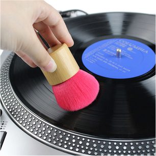 Kartáč na vinyl Enova HIFI BVA 25 s růžovými štětinami a dřevěnou rukojetí položený na černé vinylové desce na gramofonu