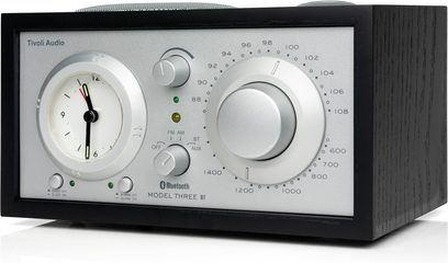Radio Tivoli Model Three BT i sort aske, sølvfarvet aluminiumsfront, ur til venstre, stor drejeknap til højre, trekvartsvisning