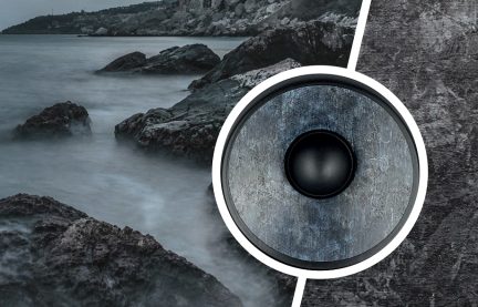 Schwarzer runder Lautsprecher von vorne gesehen in einer felsigen Kulisse am Meer, Schwarz-Weiß-Aufnahme