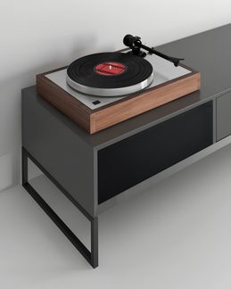 Tocadiscos de madera y metal cepillado, disco negro con etiqueta roja, brazo de lectura negro, vista en tres cuartos