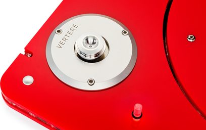 Nærbillede set ovenfra af Vertere Acoustics Pack DGX Dark Sabre hi-fi pladespiller med skinnende rød akrylchassis, cirkulært centerleje i mat aluminium indgraveret med "VERTERE", lille gennemsigtig cylindrisk stop og synlige skruer