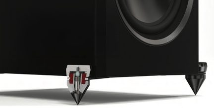 Close-up view of a black cabinet with a circular speaker and conical metal legs on a white surface