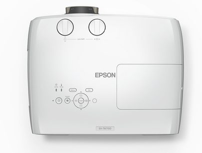Videoproiector Epson EH-TW7100 alb, vedere frontală, cu două rotiţe de reglare şi mai multe butoane în partea de sus