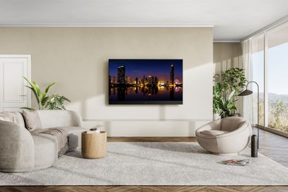 Téléviseur Panasonic TX-65MZ1500E affichant une ville illuminée la nuit, posé sur un meuble dans un salon moderne