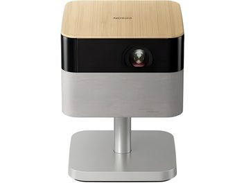 Compact white and black projector on a stand, light wood-effect top and central front lens