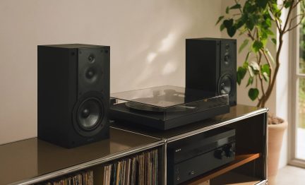 Şeffaf kapaklı siyah pikap ve iki siyah raf tipi hoparlörden oluşan Sony hi‑fi seti