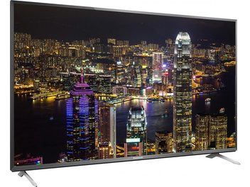Panasonic TX-55CX700E TV displaying an illuminated city at night, front view, mounted on a metal stand