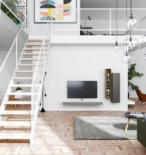 Závěsný TV stolek v bílé a dřevěné barvě v moderním obývacím pokoji se schodištěm, pohovkou, kobercem, rostlinami a designovými závěsnými svítidly