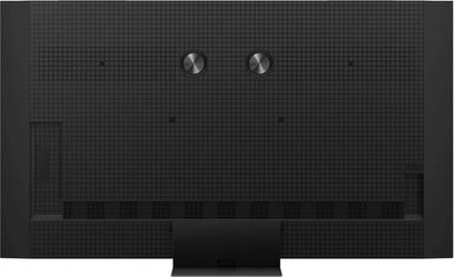 Televisor de alta definición TCL 85C9K negro de plástico mate, vista trasera mostrando un panel cuadriculado, dos discos metálicos circulares en la parte superior, rejillas de ventilación en la parte inferior y un soporte central rectangular