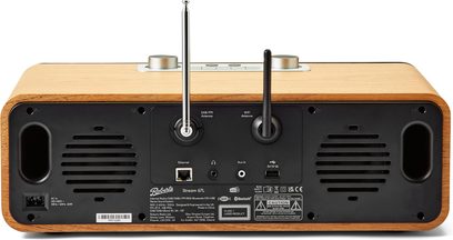 Roberts Stream 67 bordradio bagside, rektangulær kasse i lys træfinér med bagpanel i sort plast, der integrerer to højttalergitter, Ethernet-, USB- og aux-porte, sideventiler, kromt teleskopantenne og sort Wi-Fi-antenne
