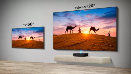 Comparativa entre videoproyector de 120 pulgadas y televisor de 60 pulgadas que muestran un paisaje desértico al atardecer en la pared de un salón moderno