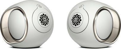 To DEVIALET Phantom Ultimate 98 dB-højttalere i Light Pearl, vist i 3/4-vinkel, med perlemorshvid plastikskal og metal sidekølere