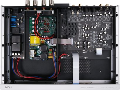 Vedere de sus a interiorului amplificatorului hi-fi stereo integrat Matrix Audio MD-1P, carcasă metalică argintie deschisă, lăsând la vedere plăci de circuit imprimate negre dens populate cu condensatori albi, transformator capsulat negru, bobine de cupru și cabluri roșii și albastre