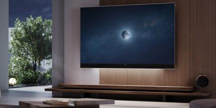 Téléviseur écran plat mural noir dans un salon moderne avec meuble en bois et image de lune à l'écran