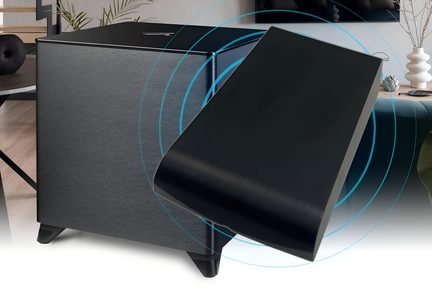 Subwoofer cubico grigio antracite con finitura in metallo spazzolato visto da tre quarti davanti, posizionato su quattro piedini neri e parzialmente coperto da un pannello nero inclinato circondato da onde blu stilizzate