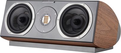 Diffusore centrale AudioVector R Center Arreté noce, vista di tre quarti anteriore destra, cabinet in impiallacciatura di noce marrone venato con lati arrotondati, frontale grigio opaco con due altoparlanti mid-woofer neri con bordi in alluminio e un tweeter a nastro dorato centrale, poggiato su una base grigia coordinata