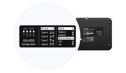 Sort mat sort aluminium digital lydinterface X SPDIF3, let skråt bagfra, guldbelagt koaksialstik på øverste kant, serigraferet overensstemmelsesmærkat og cirkulært indlæg med detaljeret skema over de fire IIS‑LVDS DIP-mikroafbrydere