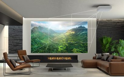 Proyector Epson EH-LS11000W proyectando una imagen de un paisaje montañoso y verde en un interior moderno y minimalista
