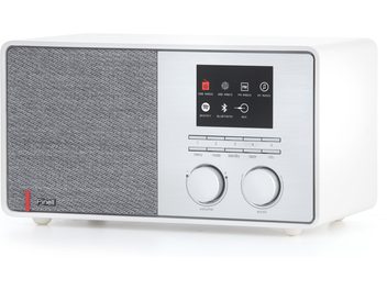 Radio de mesa Pinell of Norway Supersound 301 con carcasa de plástico blanco, vista en tres cuartos desde el frente derecho, panel frontal dividido entre rejilla de altavoz con tela gris a la izquierda y panel de control de aluminio cepillado a la derecha con pequeña pantalla negra, fila de botones y dos grandes mandos giratorios