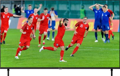 Panasonic TX-55LX800E-tv viser en fodboldkamp, røde spillere fejrer et mål, grøn bane