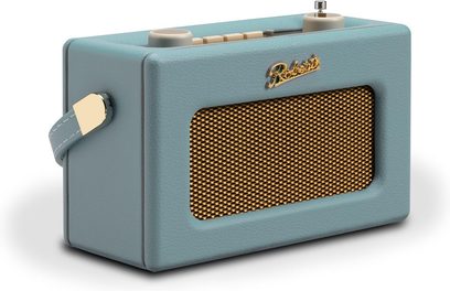 Rádio Roberts Revival Uno BT v nebesky modré barvě, obdélníkový pouzdro z jemně zrnitého umělého koženky s kovovým zlatým mřížkovým krytem reproduktoru, zlaté logo na přední straně, krémové ovládací prvky na horní části a barevně sladěný boční popruh, pohled zepředu zleva ze tří čtvrtin