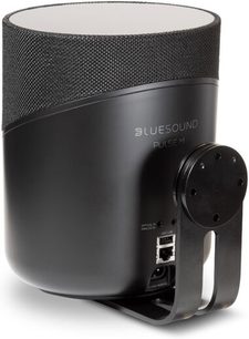 Czarna, podłączona kolumna głośnikowa BlueSound Pulse M, widok z przodu i z boku, na czarnym uchwycie ściennym, z czarną tkaniną maskującą
