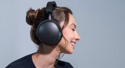 Cuffie audio wireless nere circumaurali su testa di donna di profilo, archetto opaco con dettaglio verde fluo