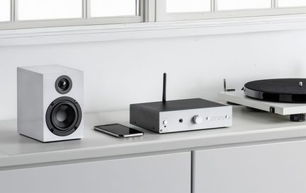 Enceinte blanche rectangulaire, smartphone noir, amplificateur noir et blanc avec antenne, platine vinyle blanche avec plateau noir