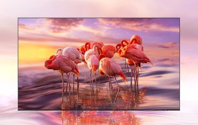 Flamingoer står i vandet og spejler en sky, rosa-orange himmel ved solnedgang