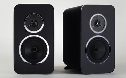 Rega System One hi-fi lemezjátszó fekete, téglalap alakú hangszórókkal, amelyek mindegyikében egy-egy kör alakú tweeter és woofer található