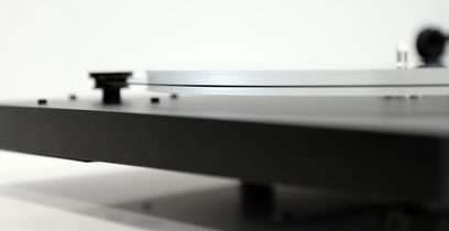 New Horizon 121 sort pladespiller, set fra siden, tonearmen er placeret på en vinylplade, tæt på